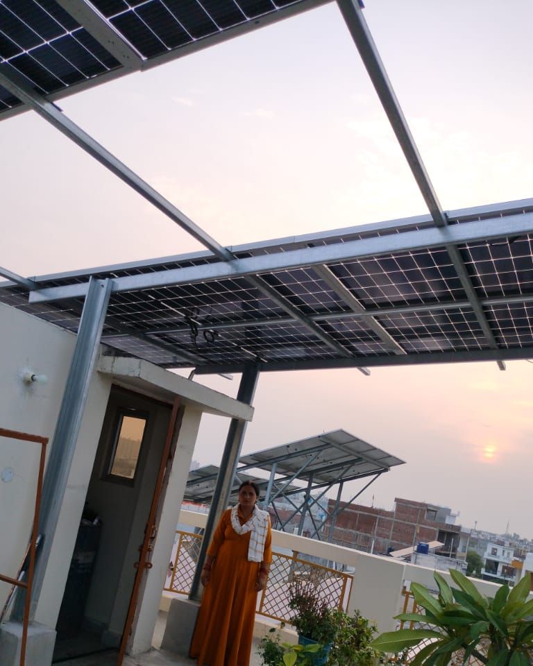 Rita Rani with the rooftop solar system SolarSpot installed, Kanausi, Lucknow