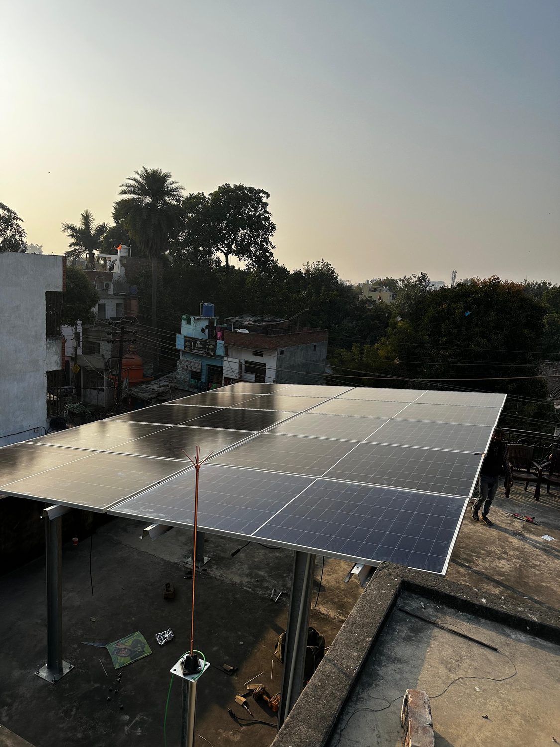 Large rooftop solar array with a lightning arrester at dusk